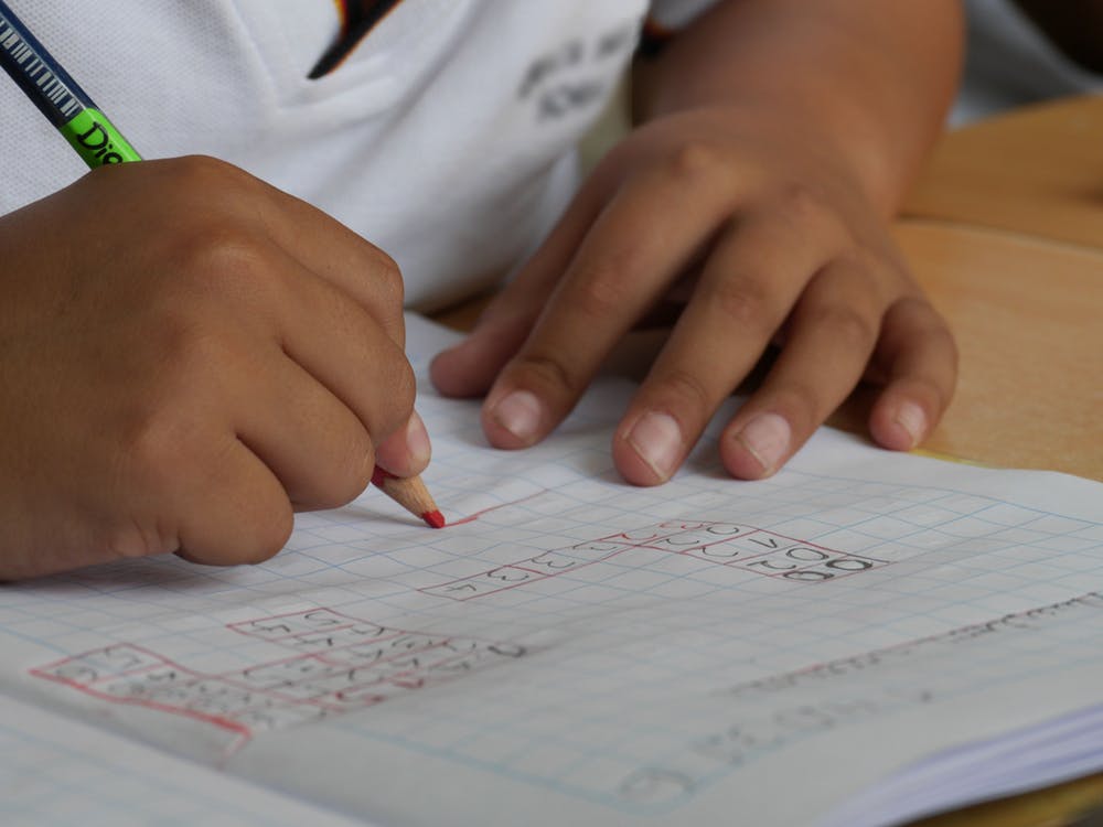 child writing in maths book